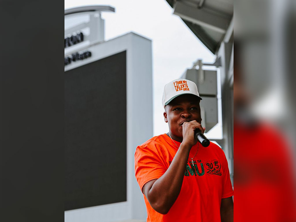 Zachary Bell, former FAMU Student Government Association president, speaks into a microphone while representing WANM 90.5 FM during an outdoor event. Bell helped support improvements to the student-run radio station through Capital Improvement Trust Fund resources as WANM celebrates 50 years of broadcasting excellence.