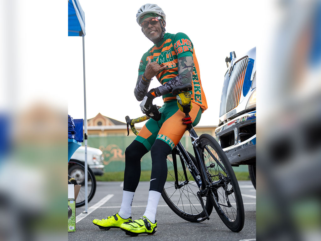 A cyclist dressed in FAMU orange and green poses with his bicycle during the fifth annual Walmart-sponsored FAMU Homecoming 5K Run/Walk on Thursday, Oct. 22, 2026, near Bragg Memorial Stadium.  Photo courtesy of Jeff Adams.