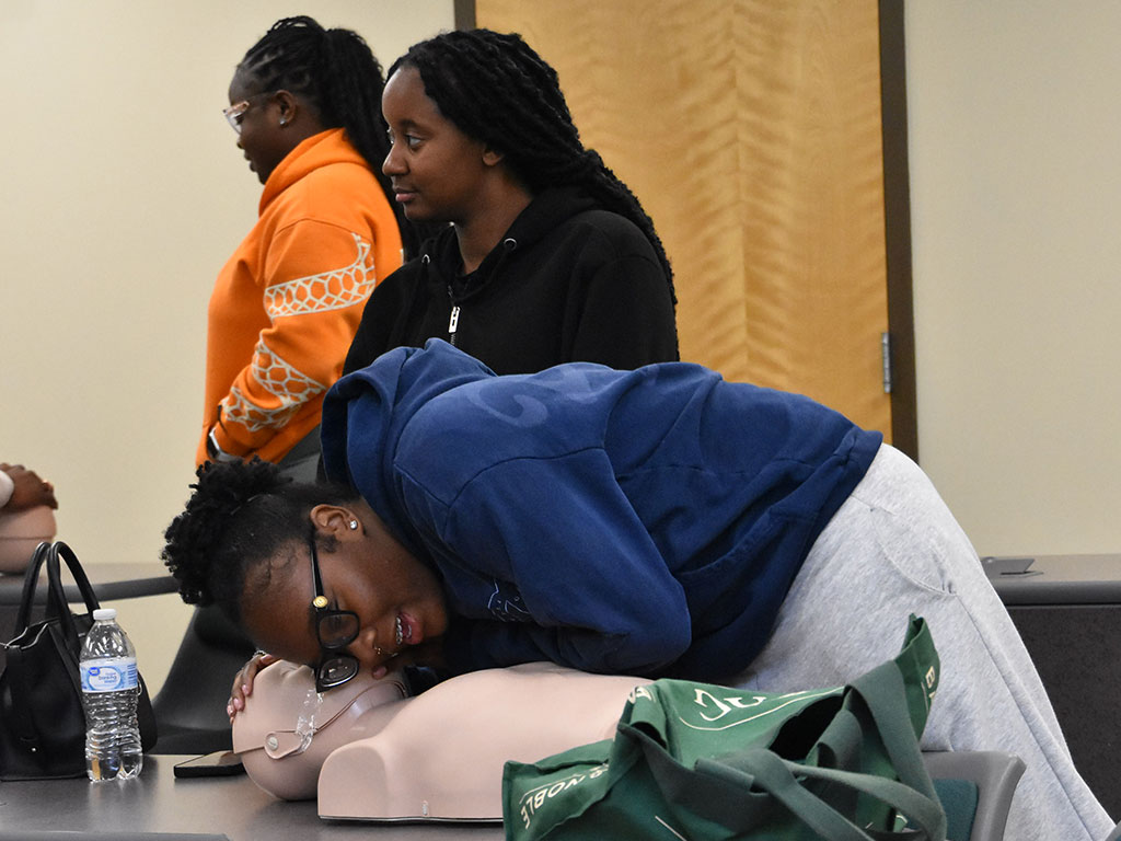 A Florida A&M University student performs rescue breathing on a training mannequin while participating in a CPR certification workshop designed to teach life-saving emergency response skills. (Photo courtesy of Willie Williams)