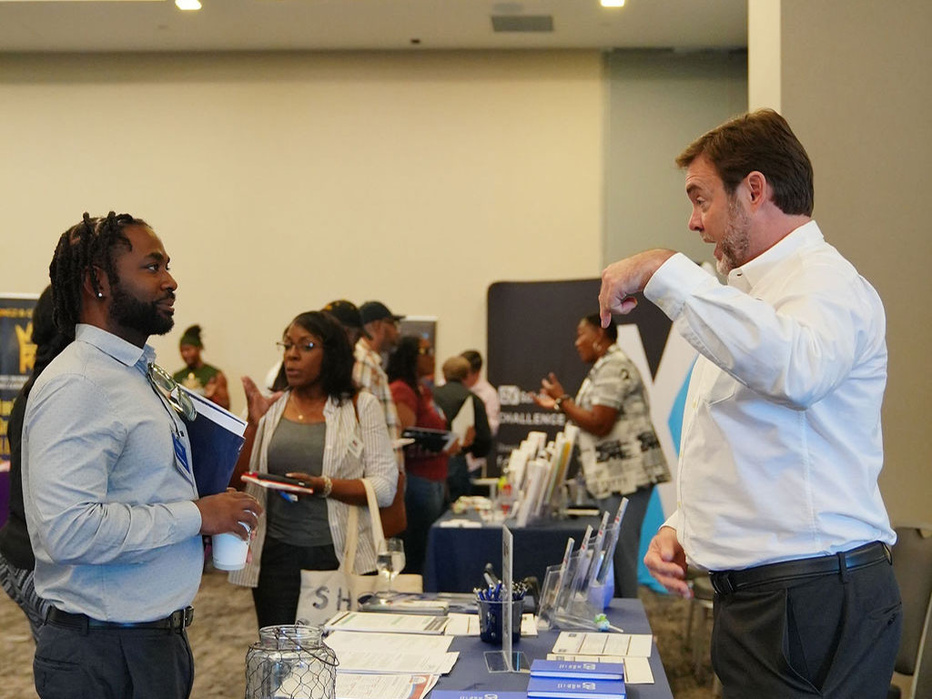 Vendor explaining his business to an interested attendee