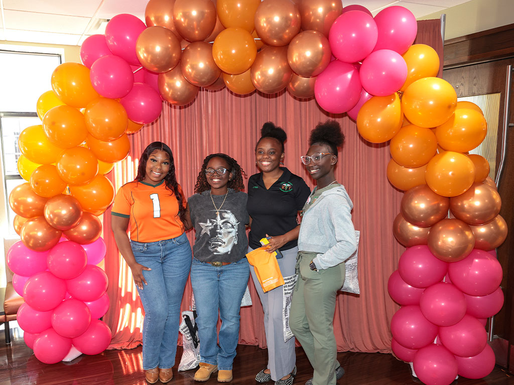 Students pause for a quick photo op beneath the vibrant balloon arch during the Expo.
