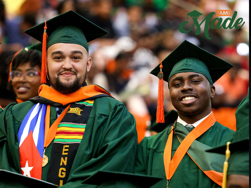 Two male grads smiling in the crowd