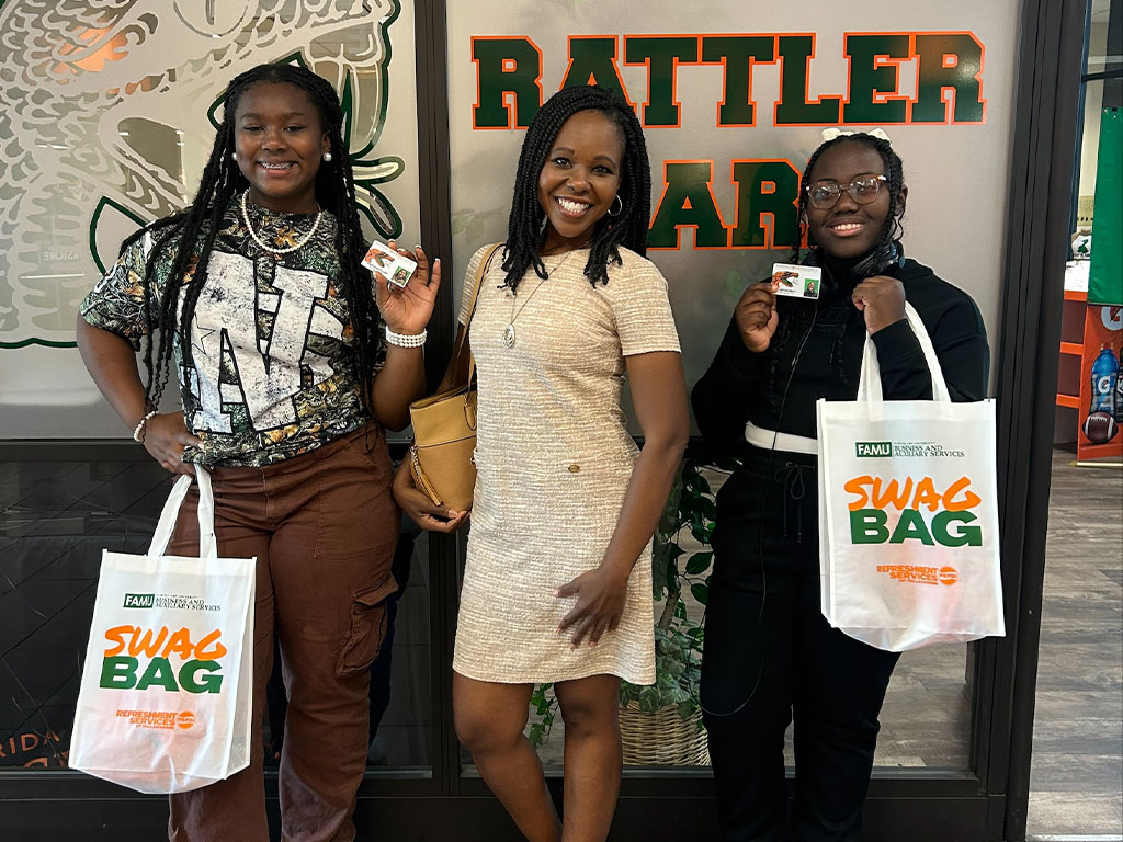 FAMU Employee poses with daughters and swag bags