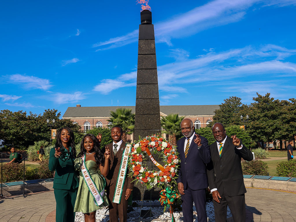 FAMU officials pose for a photo in-front of eternal flame