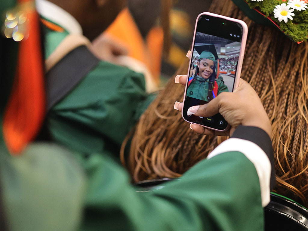 Graduate takes a selfie in the audience.