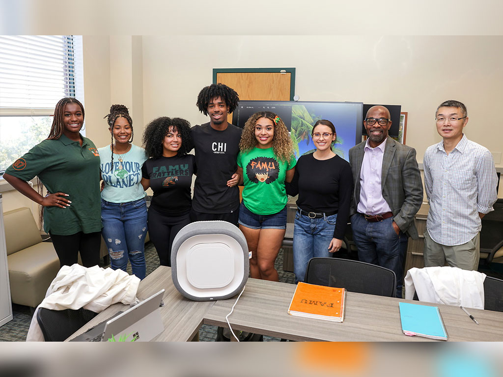 Students and faculty in Florida A&M University's School of the Environment gather around one of the Center of Excellence for Indoor Air Quality's environmental monitoring sensors. Through hands-on research, artificial intelligence and real-time data analysis, the School prepares students to address challenges related to hurricane preparedness, climate resilience and public health. (Photo courtesy of Florida A&M University.)
