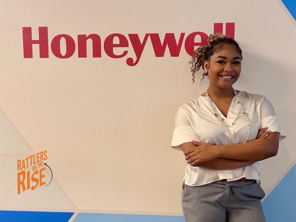 Zayda Greene poses in front of Honeywell sign in warehouse.