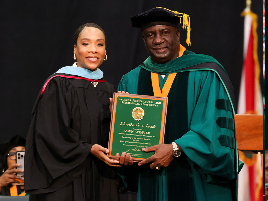 Interim President Beard presenting Fawn Weaver with a plaque