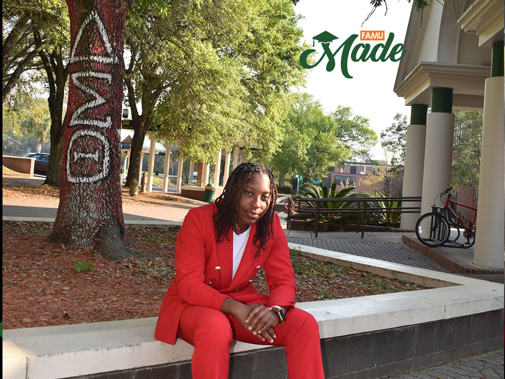 Aniyah Anderson-Cooper siting under the Delta Sigma Theta Tree