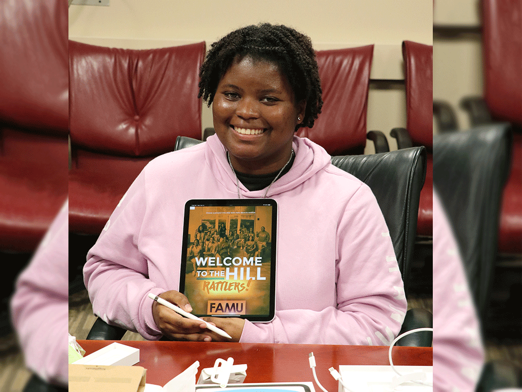 Student holding their IPad that says