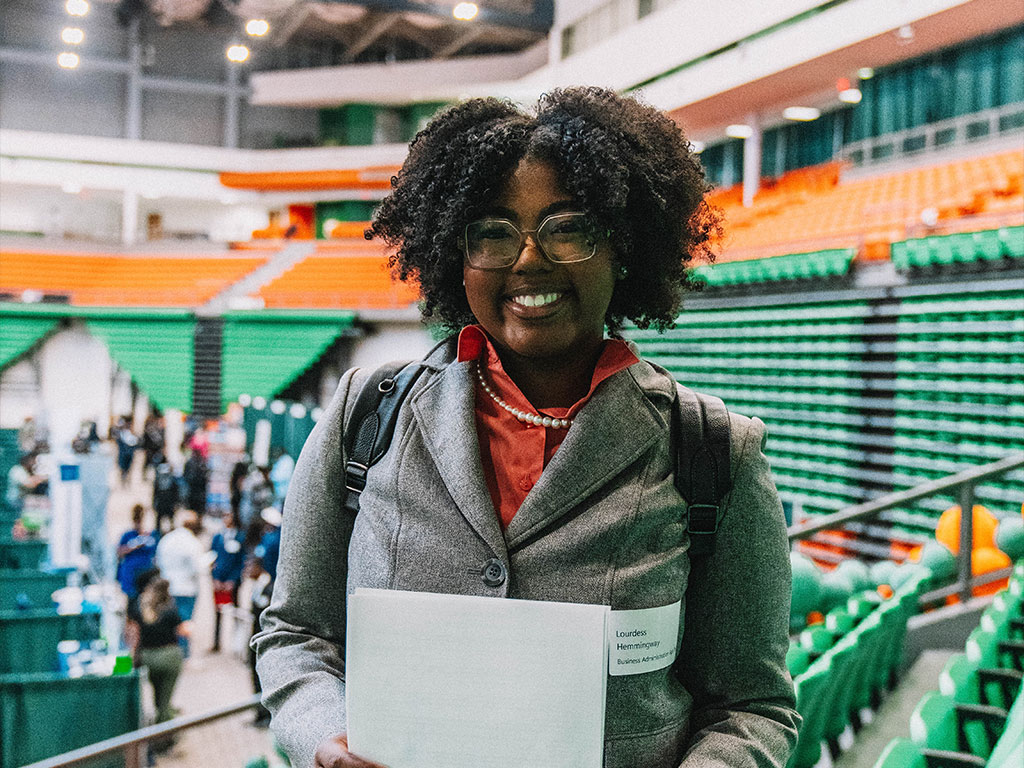 Student smiles holding certificate
