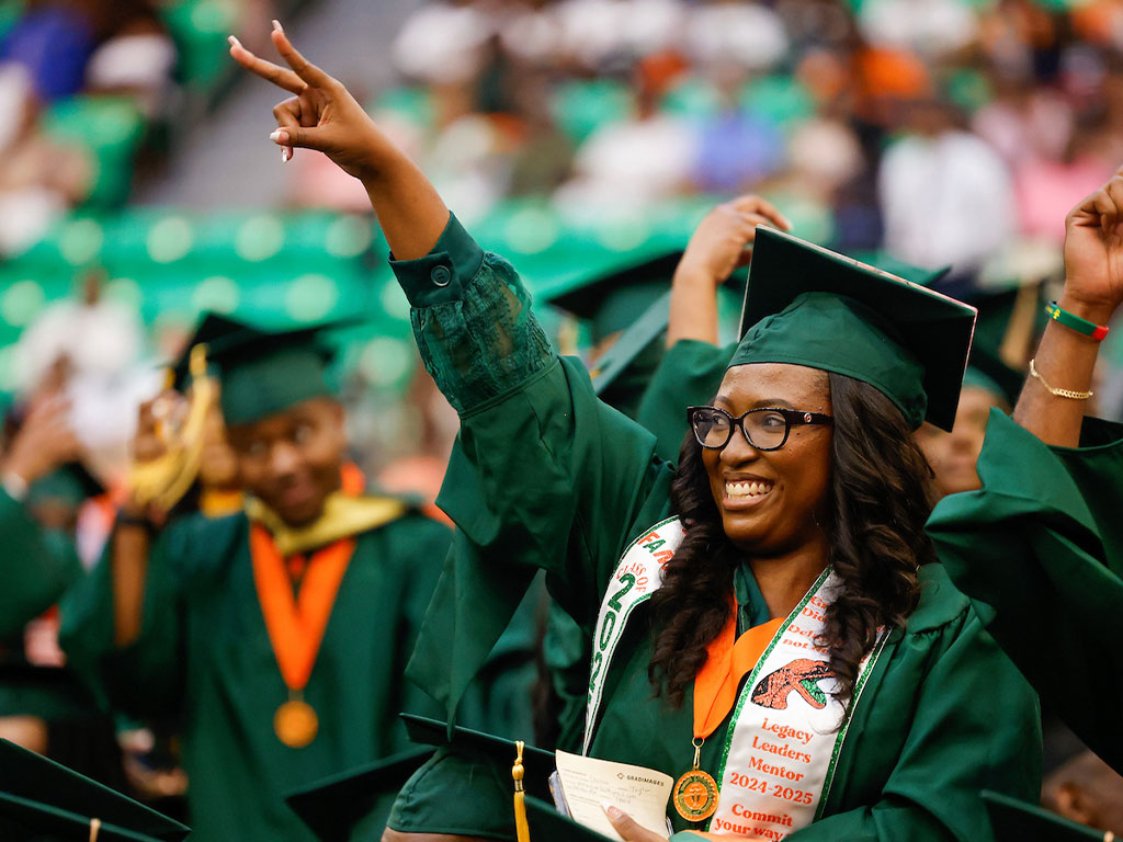 2025 Summer Commencement Graduate Giving Peace Sign