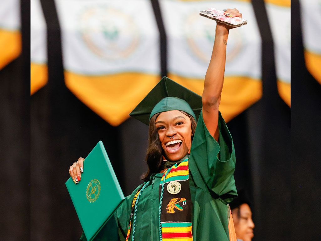 2025 Summer Commencement Young Lady Graduate with Arm Raised