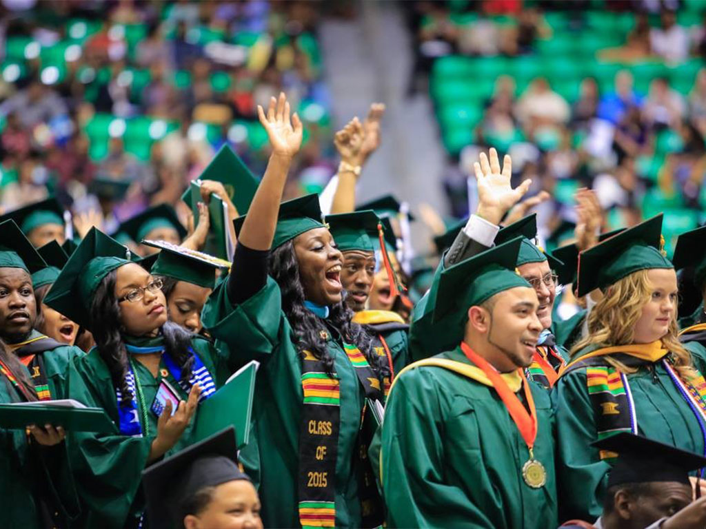 FAMU Commencement with variety of students in green graduation caps and gowns