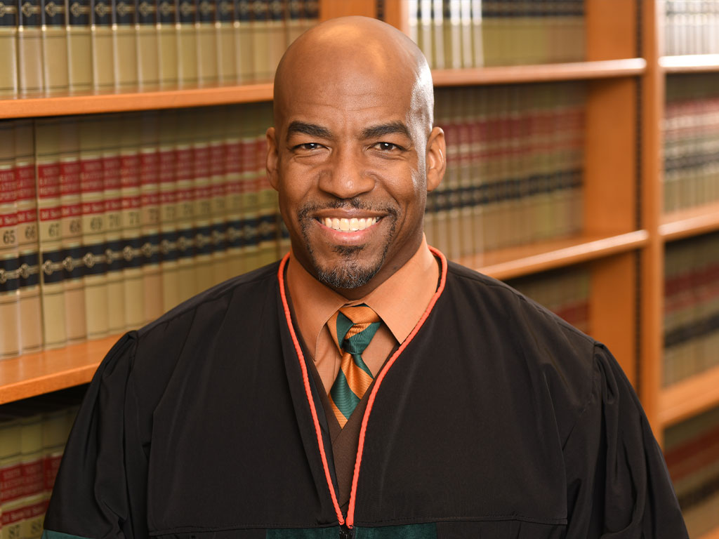 Judge Keith A. Farmer headshot in a law library.