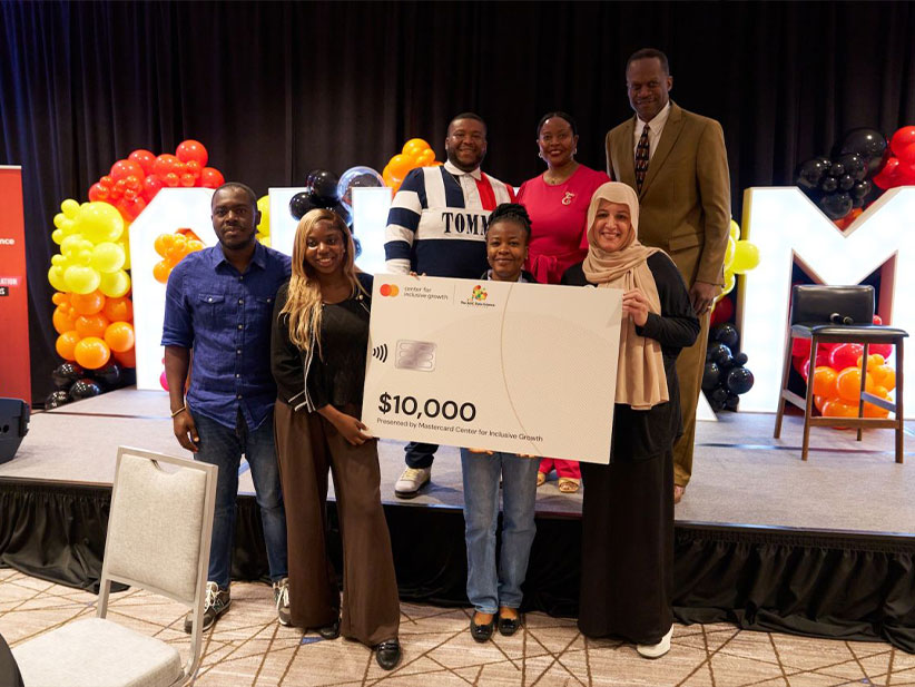 The team Ladies of Logic holding a $10,000 big check award.
