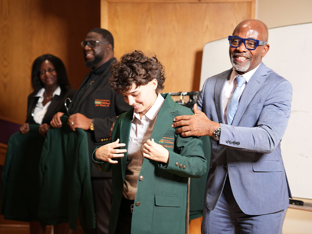 Florida A&M University environmental studies and pre-law scholar Maya Shenefelt proudly wears her green blazer, symbolizing her academic growth and accomplishments as a Nexus Scholar.