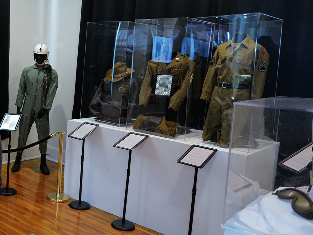 Historic military uniforms and artifacts are displayed at the Meek-Eaton Black Archives exhibit at FAMU, honoring African American service members during Black History Month.