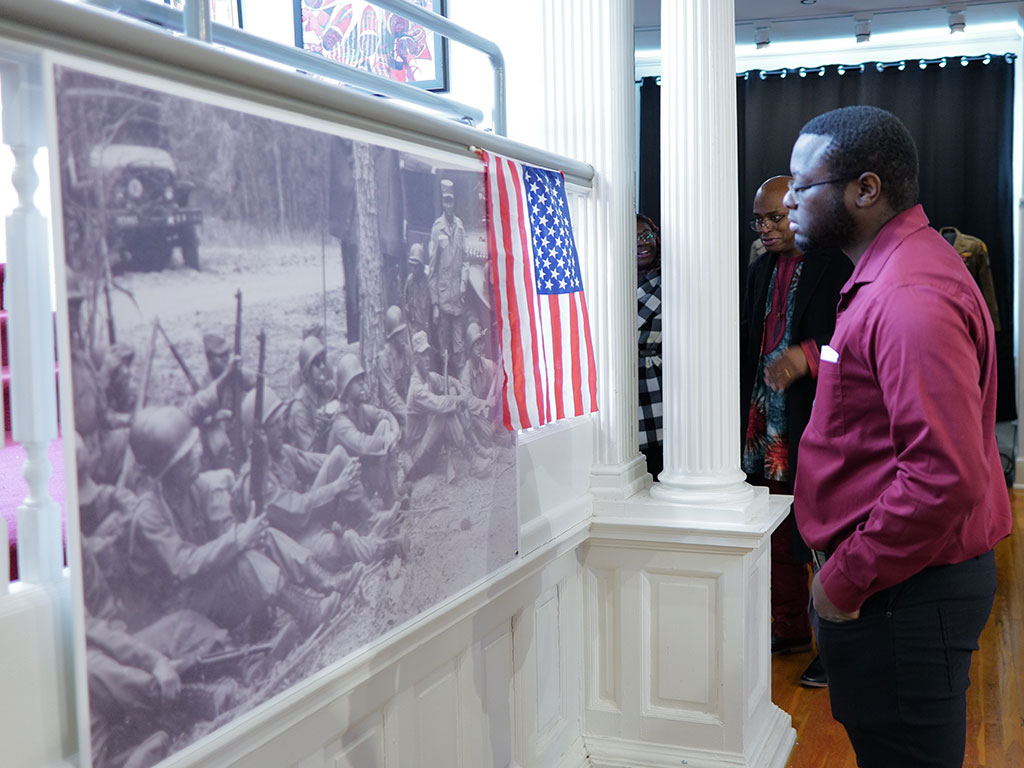 A visitor views historic images of African American military service at the Meek-Eaton Black Archives exhibit at FAMU during Black History Month.