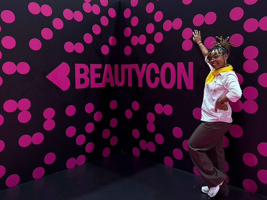 Nailah Barnes poses in front of BeautyCon sign in New Orleans