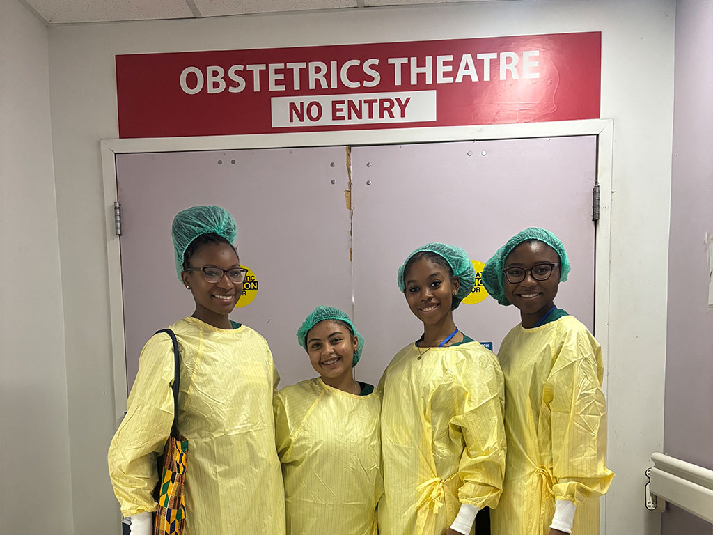 FAMU nursing students pose in front of an obstetrics sign while on summer clinicals in Ghana