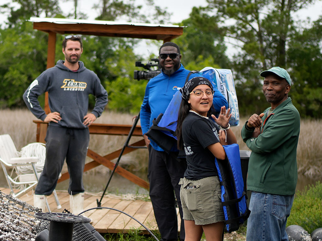Joel Blount Jr., director of student success for Florida A&M University's School of the Environment, joins environmental science student Rosemarie Rosales and community partners during a field visit to an oyster farming site in Spring Creek. The partnership provides students with hands-on research experiences while supporting local aquaculture operations through real-time environmental monitoring. Photo courtesy of Ernest Nelfrard.