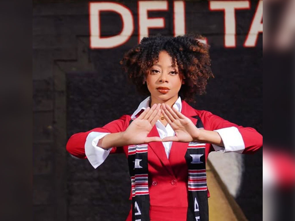 Florida A&M University alumna Rae’Kwan Bostic poses in Delta Sigma Theta Sorority, Inc. attire, representing sisterhood, scholarship and service as part of her continued journey beyond FAMU.
