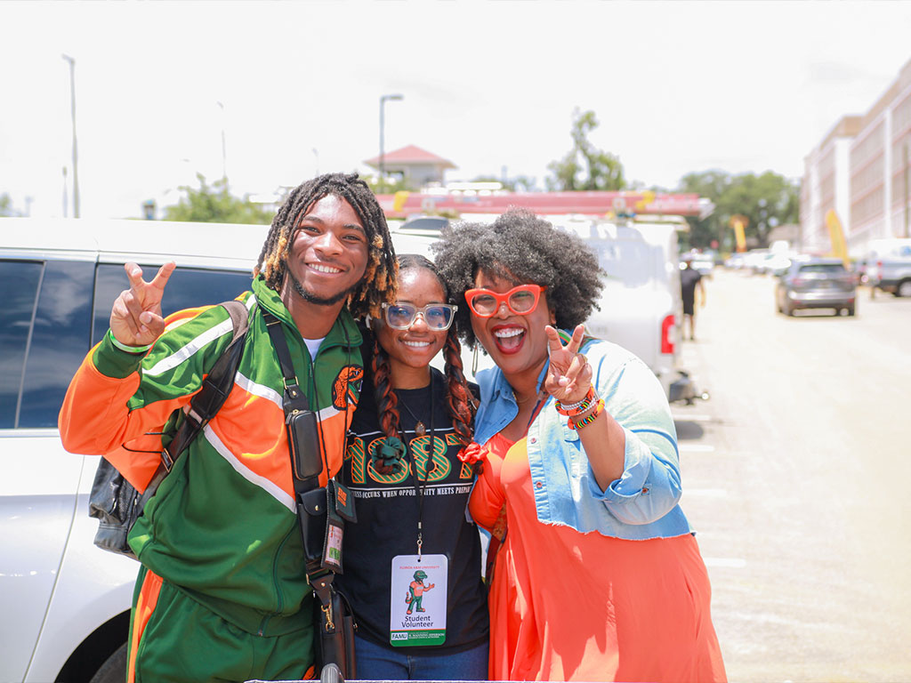 Ricky II poses with his mother and a student volunteer
