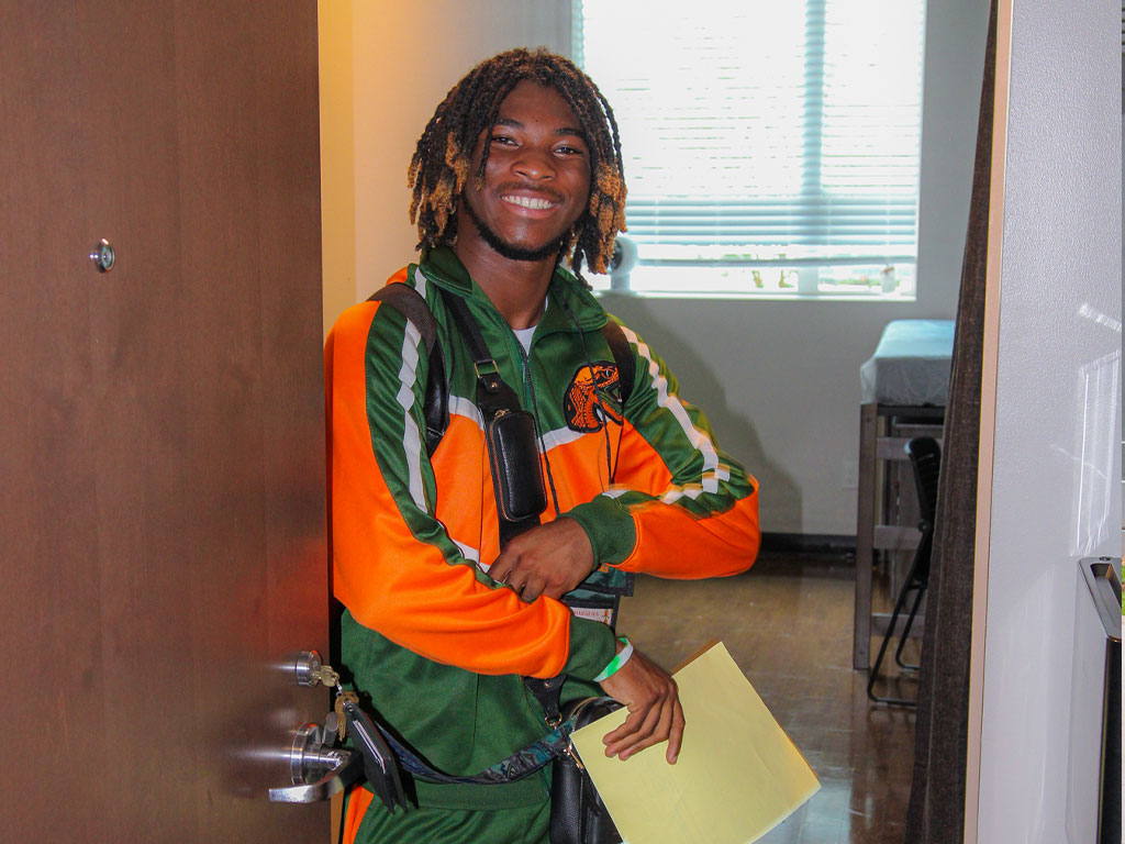 Ricky II Stans with excitement in front of his room door.