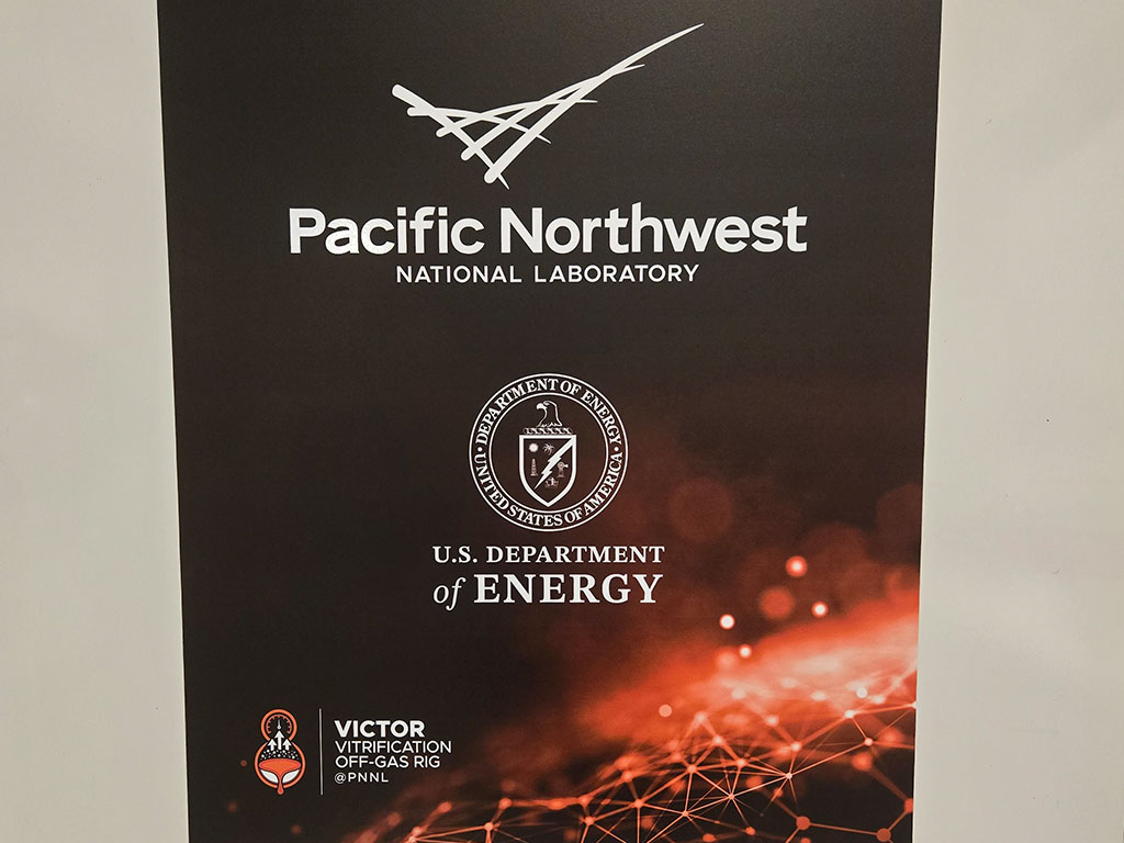 A display at Pacific Northwest National Laboratory (PNNL) highlights the U.S. Department of Energy's partnership with the national laboratory system and the VICTOR vitrification off-gas research program, one of the many innovative technologies showcased during Florida A&M University School of the Environment's educational visit. (Photo courtesy of Joel Blount.)