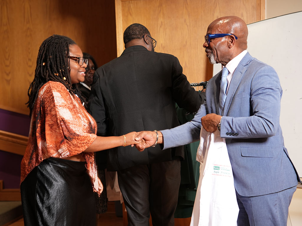 School of the Environment Dean Victor M. Ibeanusi, Ph.D., congratulates an incoming Nexus Scholar during the White Coat and Greening Ceremony. The white coat marks the beginning of students’ academic and research experiences in the Nexus Scholars-in-Residence Program.