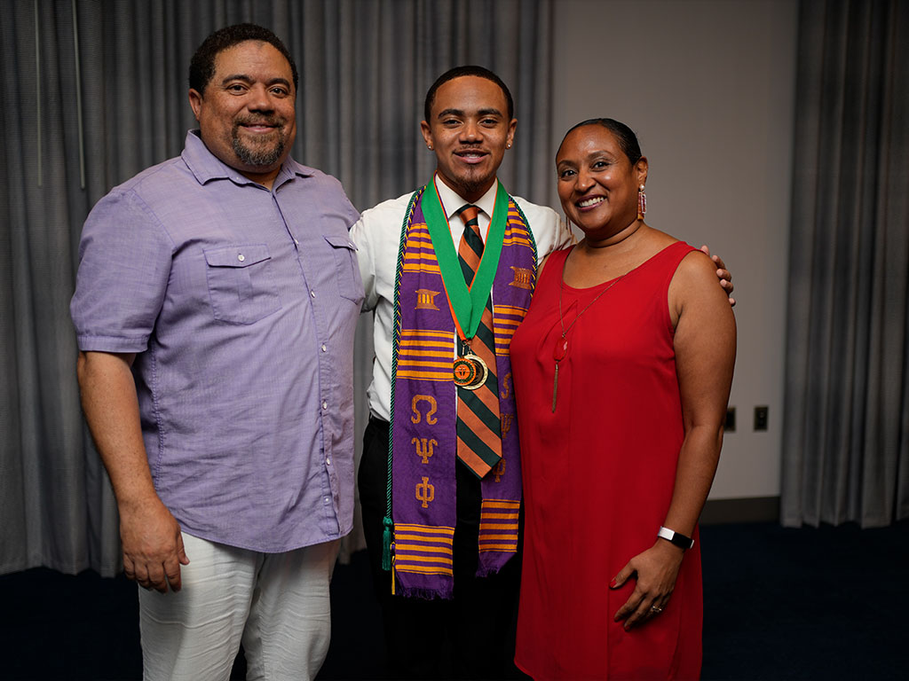 Williams poses with hisnparents after graduation 