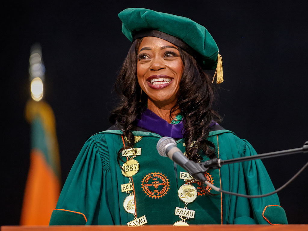 President Marva B. Johnson, J.D. Smiling at Commencment Podium