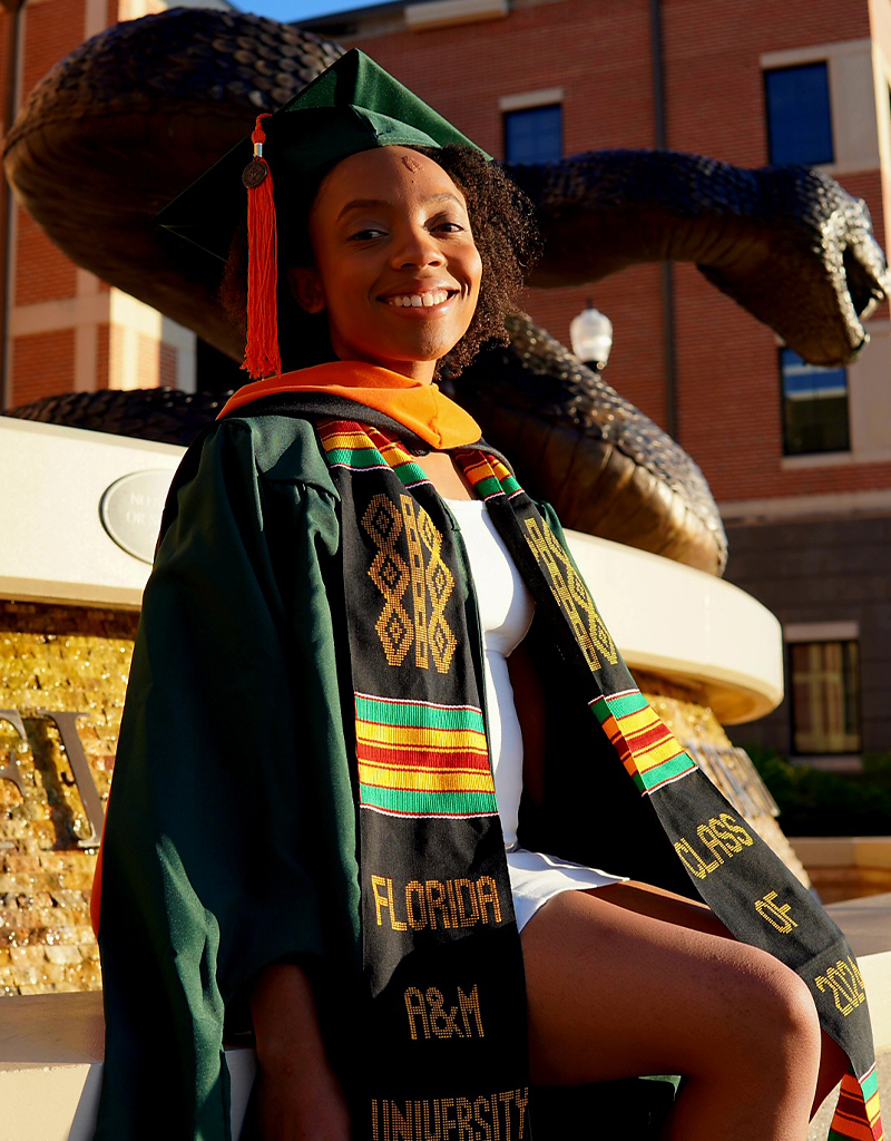 Briona Carswell poses in front of the bronze Rattler statue in front of the Florida A&M University (FAMU) Center for Access and Student Success (CASS) Building.